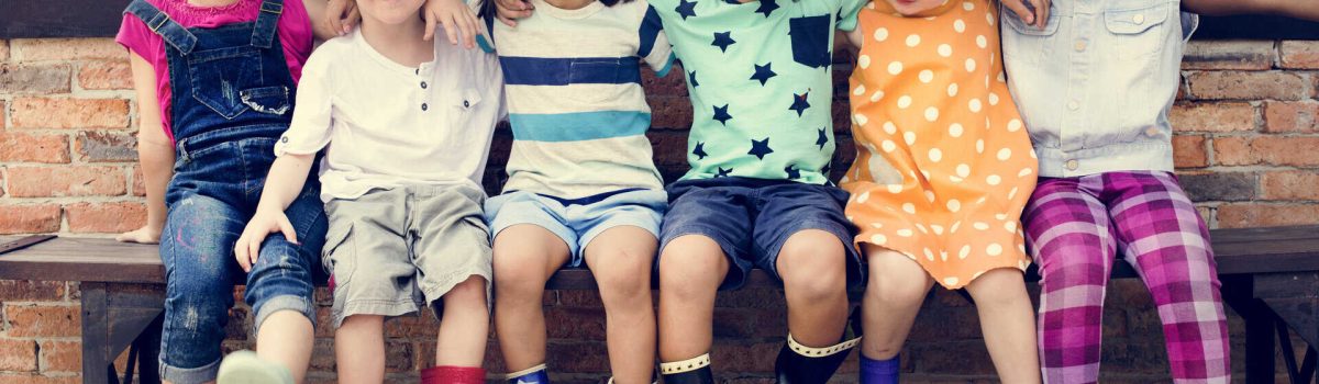 Group of kindergarten kids friends arm around sitting and smiling fun